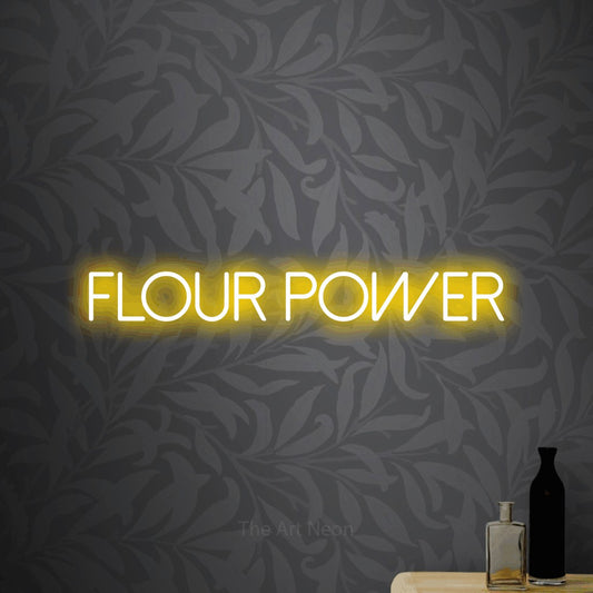 Yellow LED neon sign reading "Flour Power" against light grey floral wallpaper for kitchen décor
