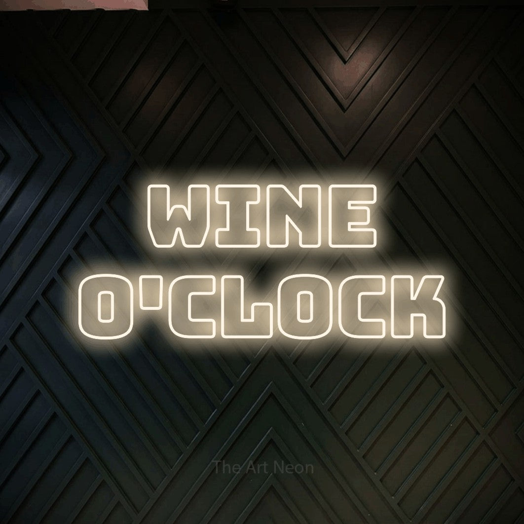 Warm white outline-style LED neon sign reading "Wine O'Clock" against a dark geometric wood wall for kitchen décor