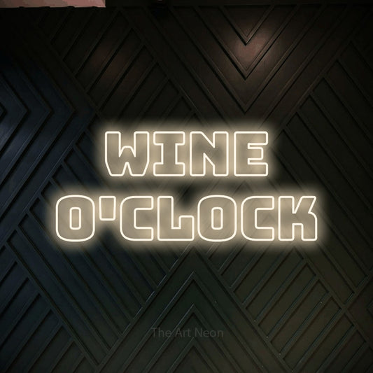 Warm white outline-style LED neon sign reading "Wine O'Clock" against a dark geometric wood wall for kitchen décor