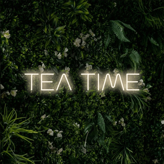 Warm white LED neon sign reading "Tea Time" against a leafy green wall for kitchen décor