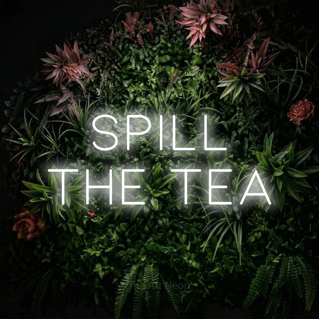 Cool white LED neon sign reading "Spill the Tea" against a flowering garden wall for kitchen décor