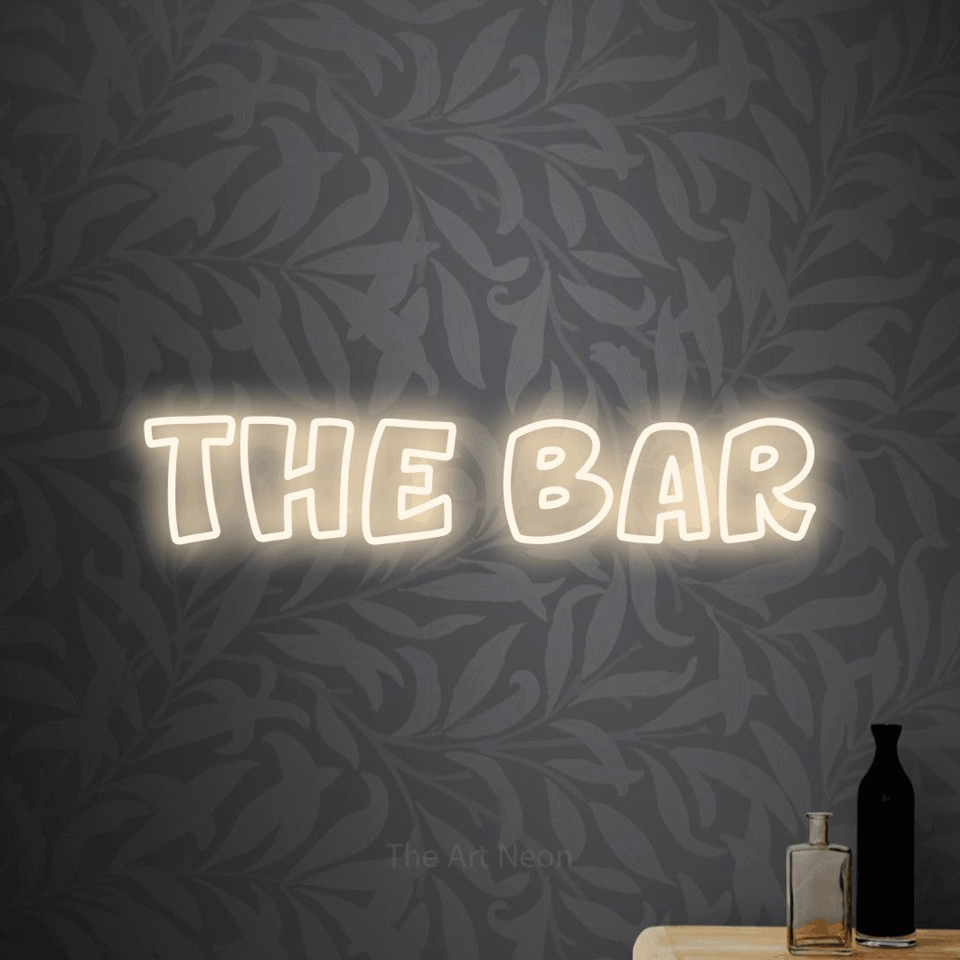 Warm white outline-style LED neon sign reading "The Bar" against light grey floral wallpaper for bar décor
