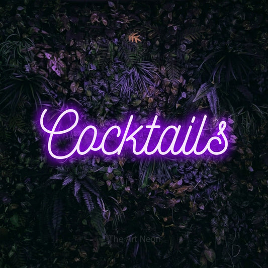 Purple script-style LED neon sign reading "Cocktails" against a purple floral wall for bar décor