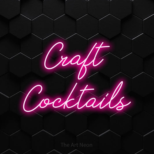 Hot pink script-style LED neon sign reading "Craft Cocktails" against a black hexagonal wall for bar décor