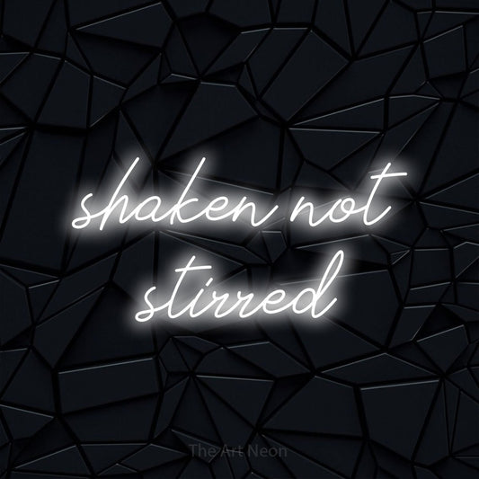 Cool white script-style LED neon sign reading "Shaken Not Stirred" against a black faceted wall for bar décor