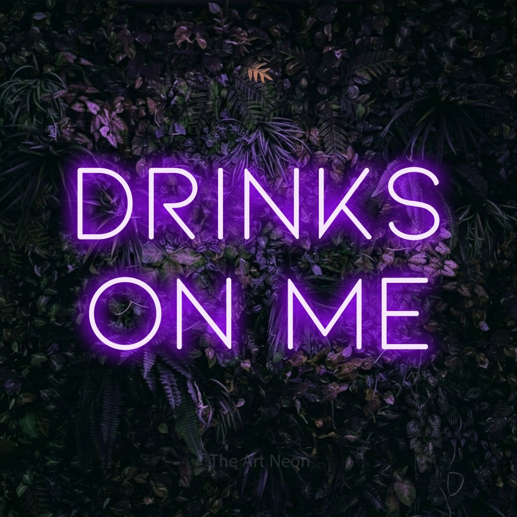 Purple LED neon sign reading "Drinks on Me" against a purple floral wall for bar décor