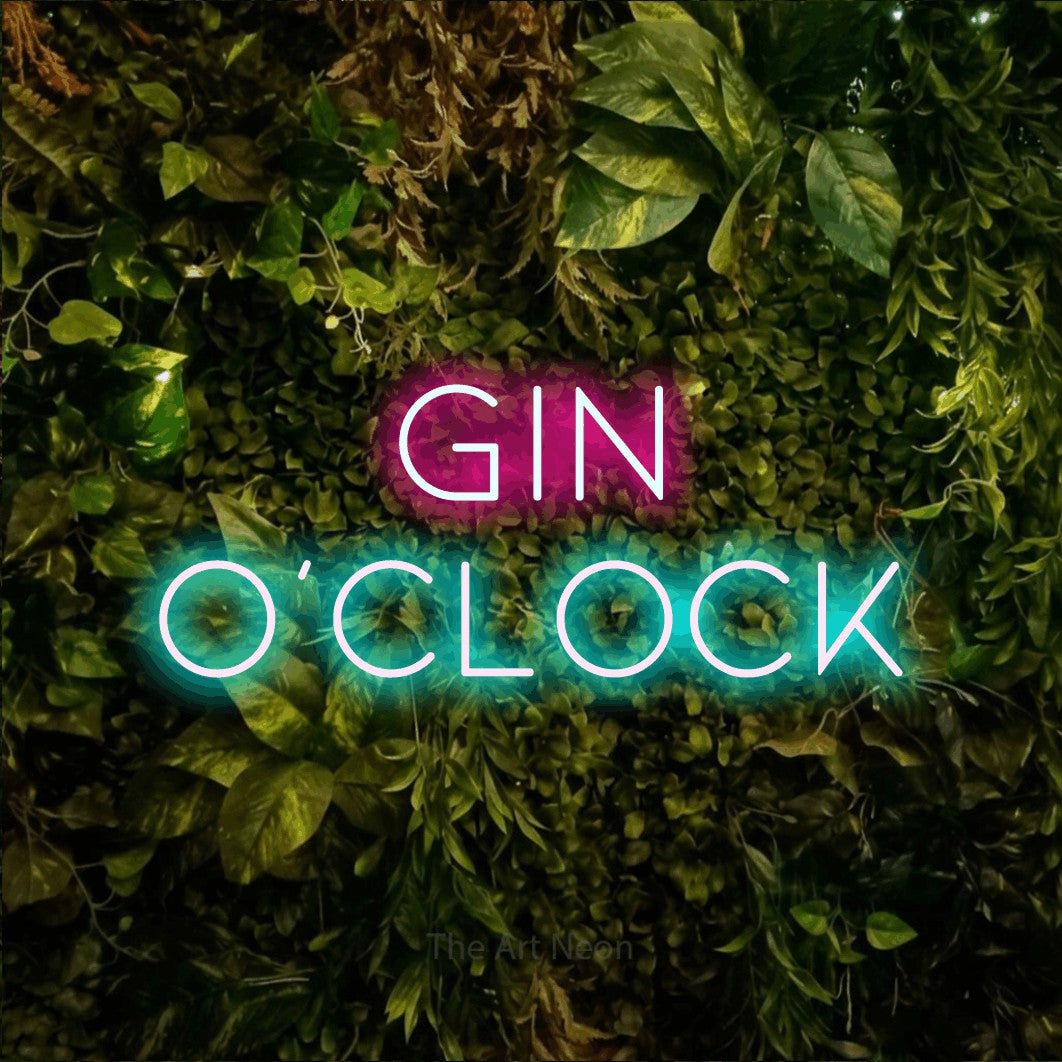 Ice blue and hot pink LED neon sign reading "Gin O'Clock" against a textured moss and foliage wall for bar décor
