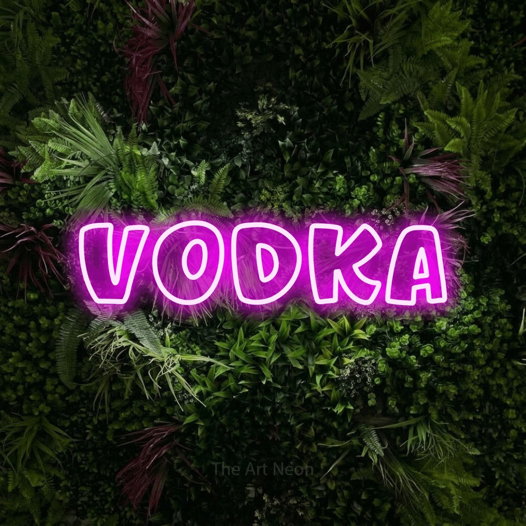 Pink outline-style LED neon sign reading "Vodka" against a lush garden wall with pink flowers for bar décor