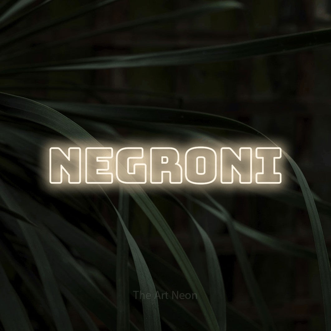 Warm white outline-style LED neon sign reading "Negroni" against dark tropical leaves for bar décor
