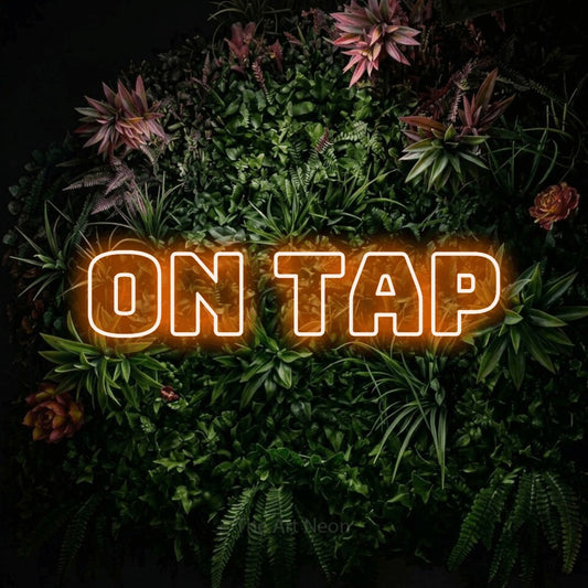Orange outline-style LED neon sign reading "On Tap" against a flowering garden wall for bar décor