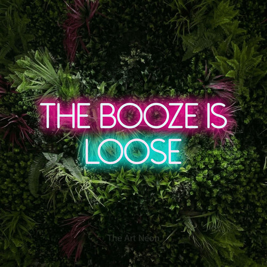 Ice blue and hot pink LED neon sign reading "The Booze is Loose" against a lush garden wall with pink flowers for bar décor