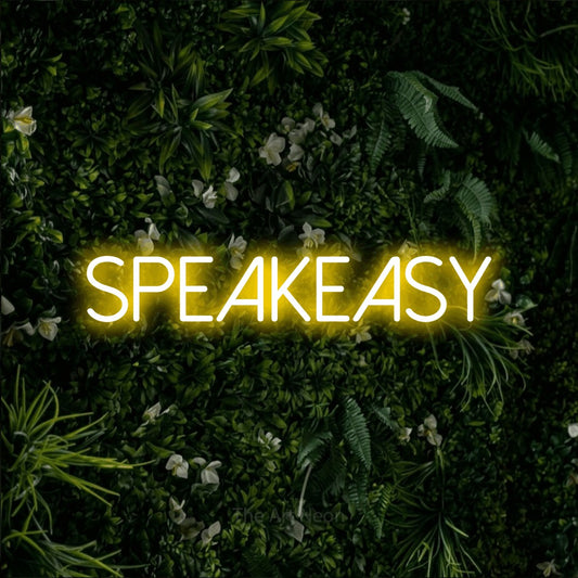 Yellow LED neon sign reading "Speakeasy" against a leafy green wall for bar décor