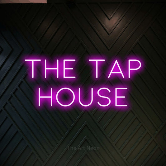 Pink LED neon sign reading "The Tap House" against a dark geometric wood wall for bar décor