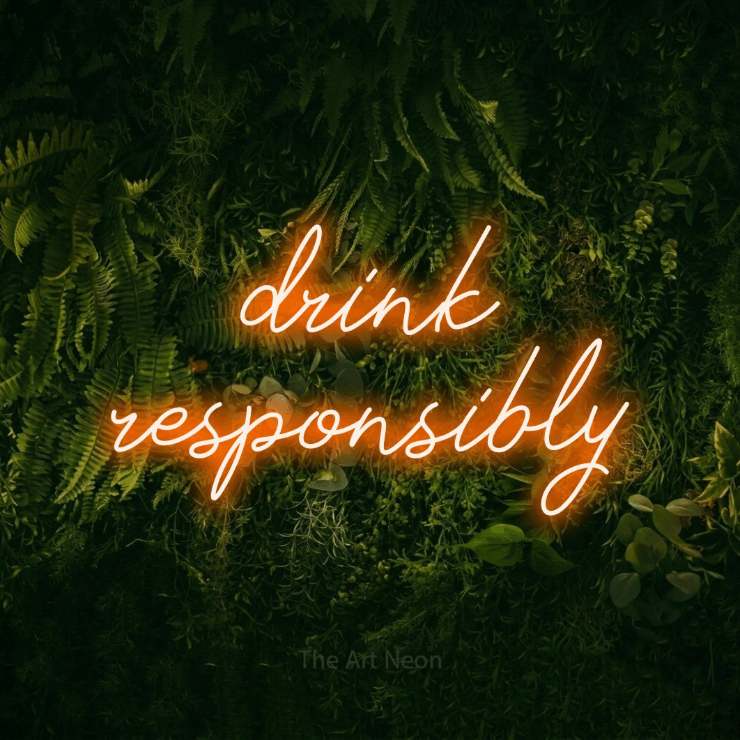 Orange script-style LED neon sign reading "Drink Responsibly" against a moss-covered green wall for bar décor