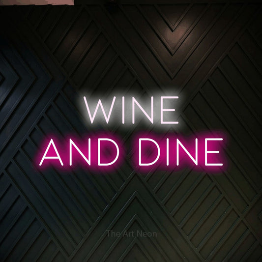 Hot pink and cool white LED neon sign reading "Wine and Dine" against a dark geometric wood wall for bar décor