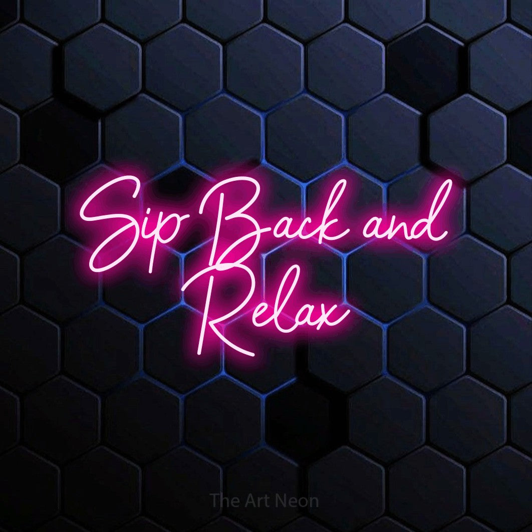 Hot pink script-style LED neon sign reading "Sip Back and Relax" against a blue hexagonal wall for bar décor