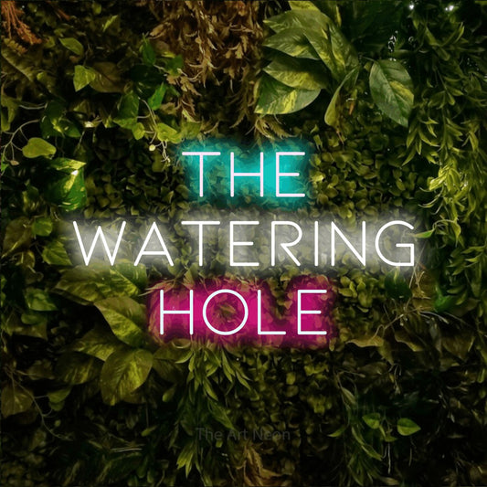 Multicolour LED neon sign reading "The Watering Hole" against a textured moss and foliage wall for bar décor
