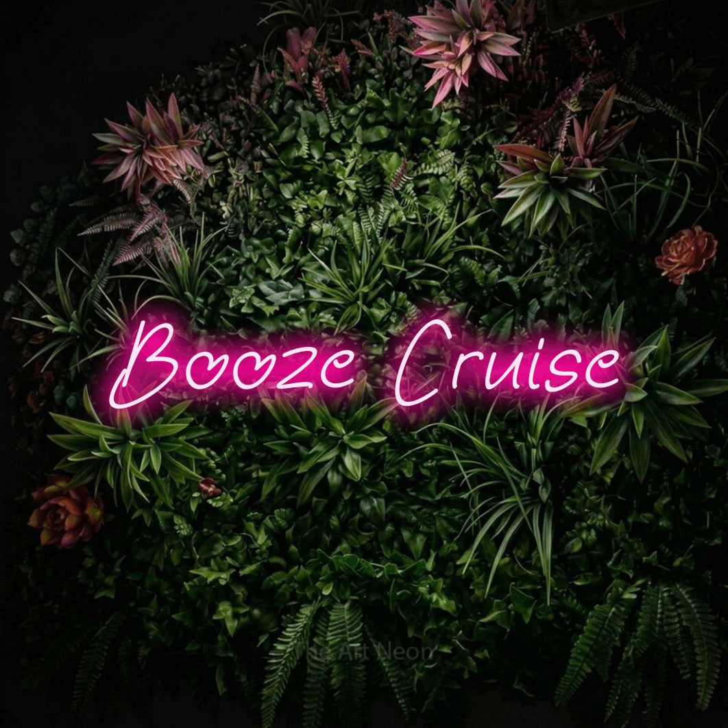 Hot pink LED neon sign reading "Booze Cruise" against a flowering garden wall for bar décor