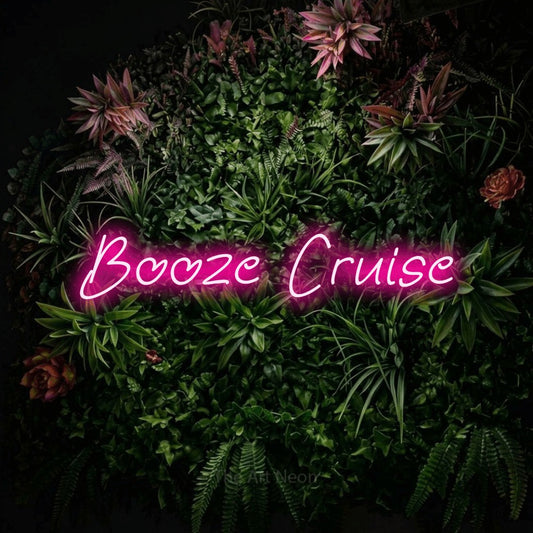 Hot pink LED neon sign reading "Booze Cruise" against a flowering garden wall for bar décor