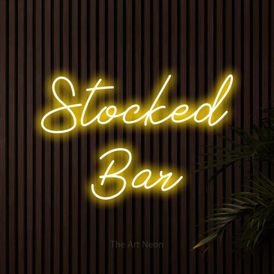 Yellow script-style LED neon sign reading "Stocked Bar" against dark wooden slats for bar décor