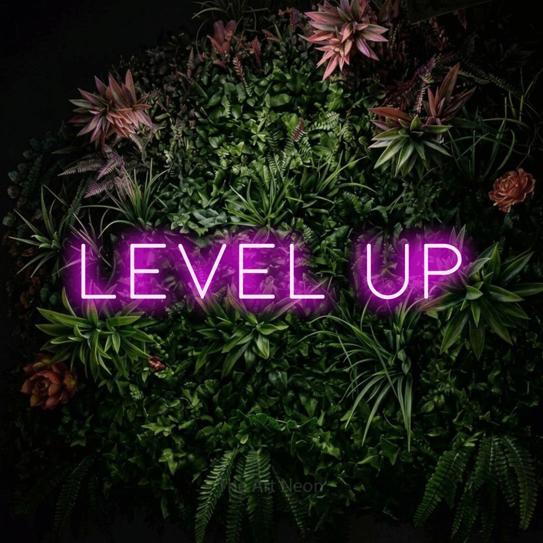 Pink LED neon sign reading "Level Up" against a flowering garden wall for gaming room décor