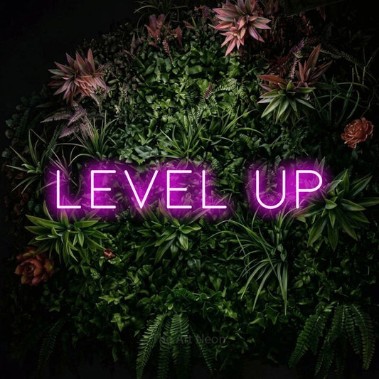 Pink LED neon sign reading "Level Up" against a flowering garden wall for gaming room décor