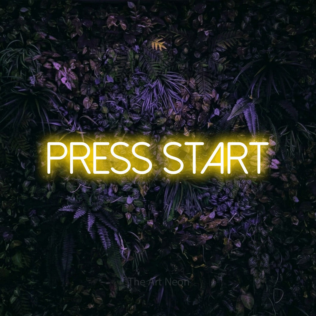 Yellow LED neon sign reading "Press Start" against a purple floral wall for gaming room décor