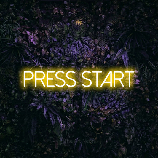 Yellow LED neon sign reading "Press Start" against a purple floral wall for gaming room décor
