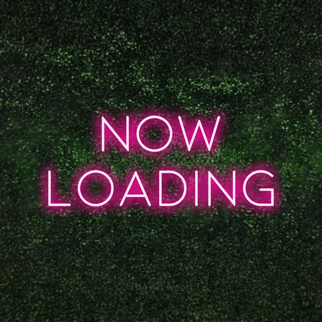 Enseigne néon à DEL à lumière rose vif, affichant « Now Loading » sur un mur texturé de mousse verte, pour décorer une salle de jeu
