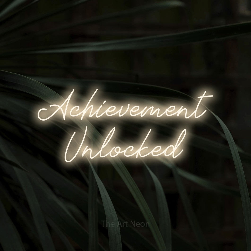 Enseigne néon à DEL à lumière blanche chaude, de style manuscrit, affichant « Achievement Unlocked » sur des feuilles tropicales foncées, pour décorer une salle de jeu