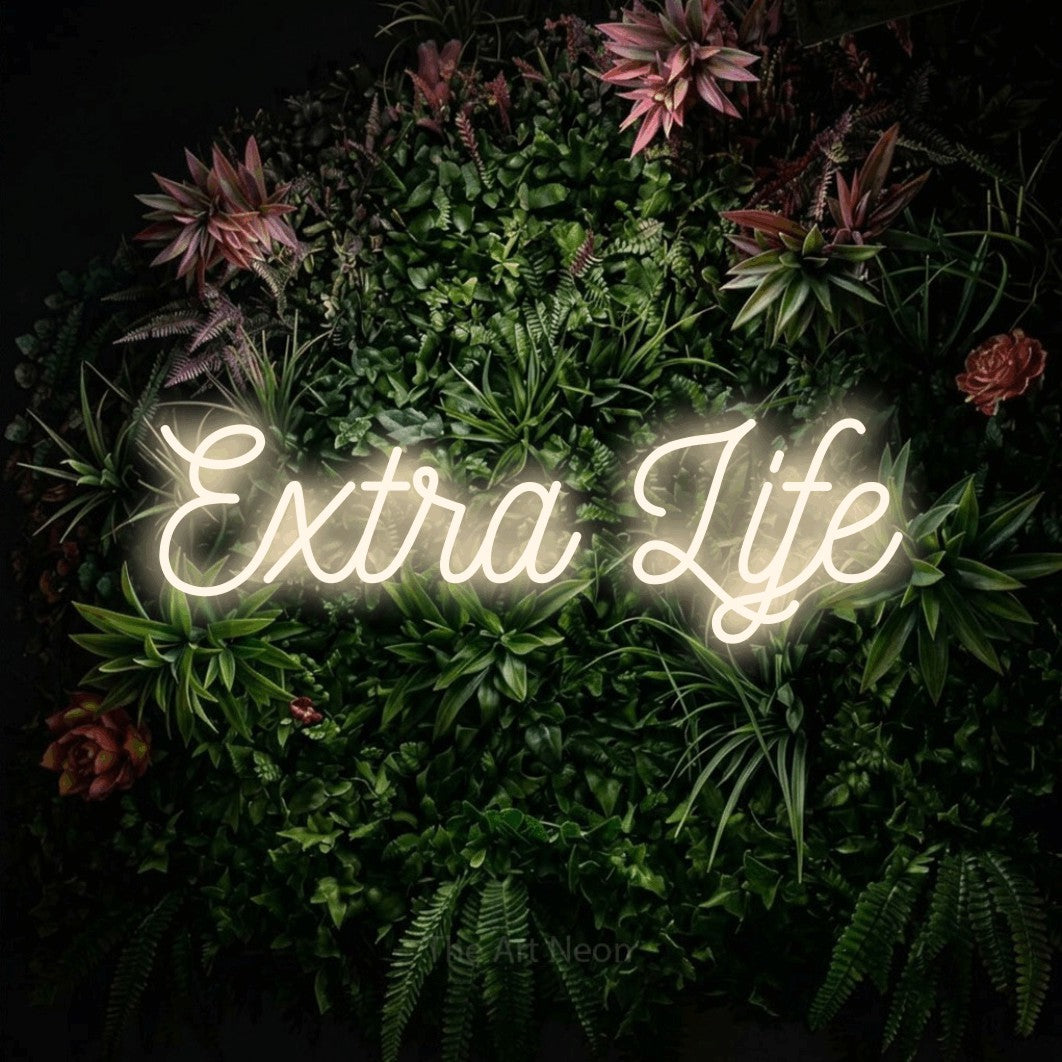 Enseigne néon à DEL à lumière blanche chaude, de style manuscrit, affichant « Extra Life » sur un mur de jardin fleuri, pour décorer une salle de jeu