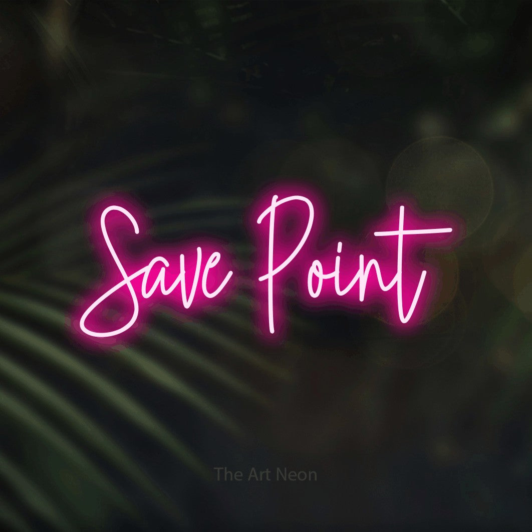 Enseigne néon à DEL à lumière rose vif, de style manuscrit, affichant « Save Point » sur des feuilles de palmier foncées et floues, pour décorer une salle de jeu