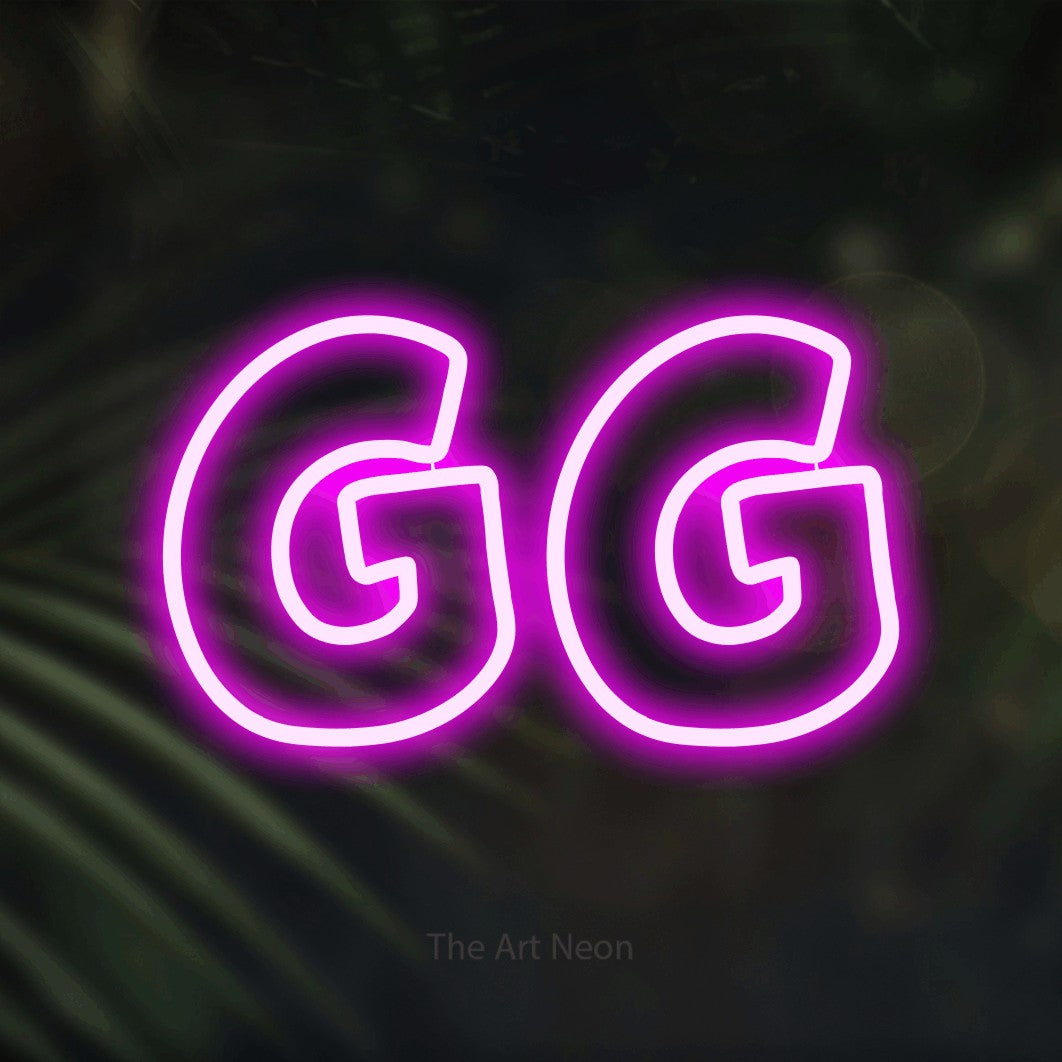 Pink outline-style LED neon sign reading "GG" against dark blurred palm leaves for gaming room décor