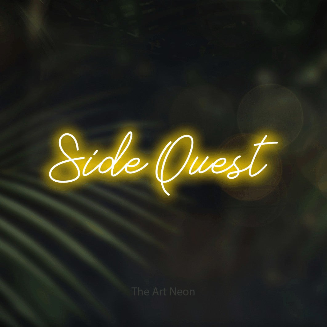 Enseigne néon à DEL à lumière jaune, de style manuscrit, affichant « Side Quest » sur des feuilles de palmier foncées et floues, pour décorer une salle de jeu