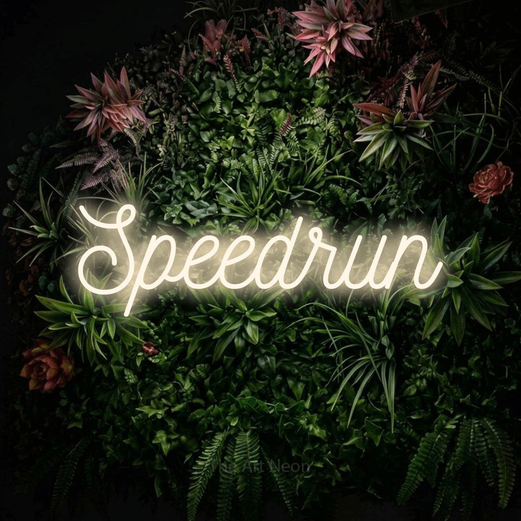 Warm white script-style LED neon sign reading "Speedrun" against a flowering garden wall for gaming room décor