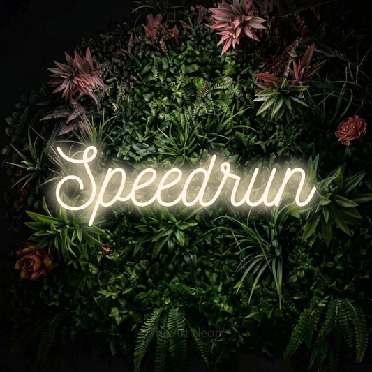 Warm white script-style LED neon sign reading "Speedrun" against a flowering garden wall for gaming room décor