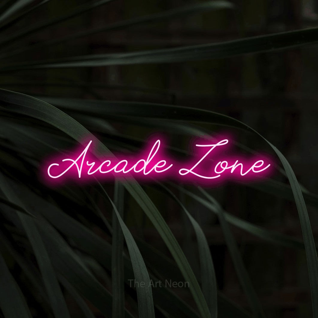 Hot pink script-style LED neon sign reading "Arcade Zone" against dark tropical leaves for gaming room décor