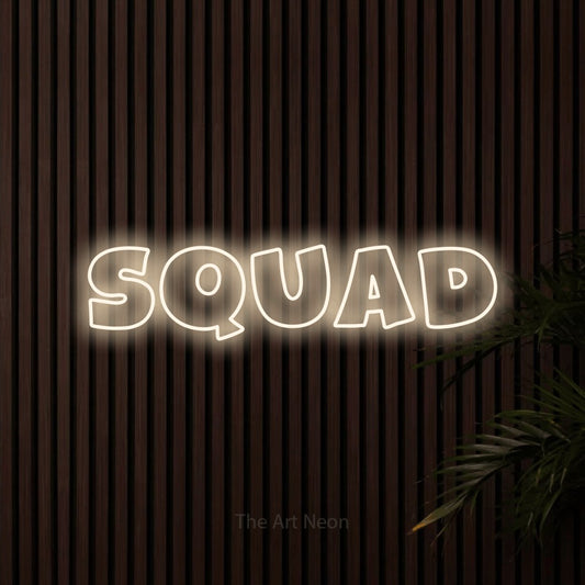 Warm white outline-style LED neon sign reading "Squad" against dark wooden slats for gaming room décor