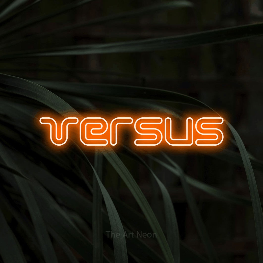 Orange outline-style LED neon sign reading "Versus" against dark tropical leaves for gaming room décor
