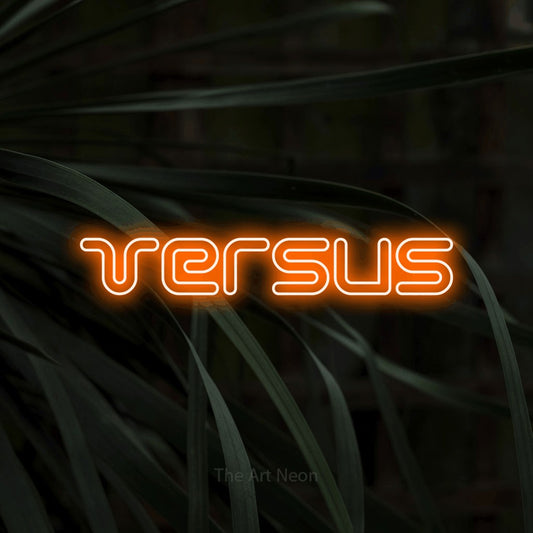 Orange outline-style LED neon sign reading "Versus" against dark tropical leaves for gaming room décor
