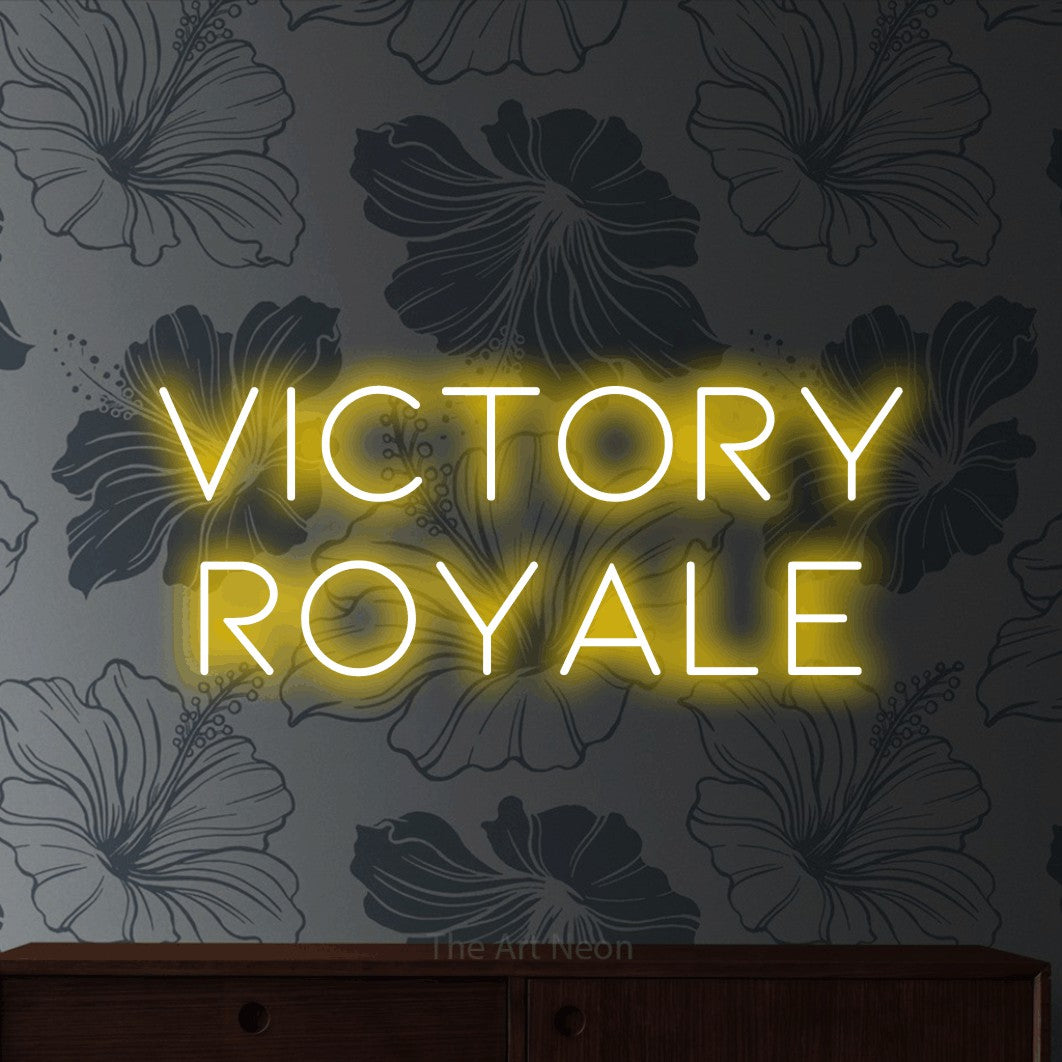 Yellow LED neon sign reading "Victory Royale" against grey floral wallpaper for gaming room décor