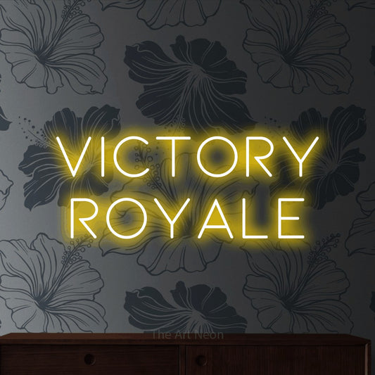 Yellow LED neon sign reading "Victory Royale" against grey floral wallpaper for gaming room décor