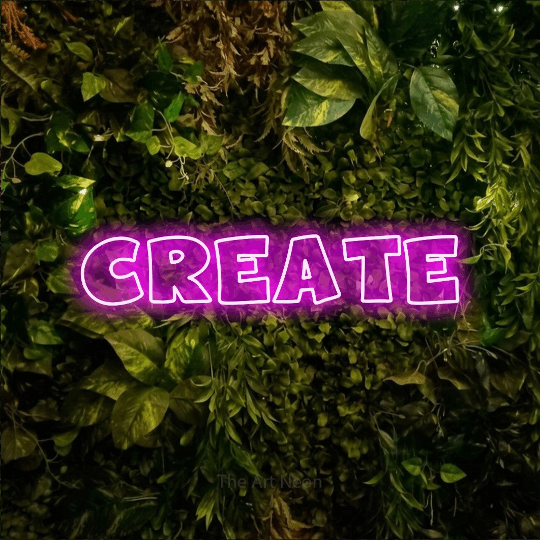 Pink outline-style LED neon sign reading "Create" against a textured moss and foliage wall