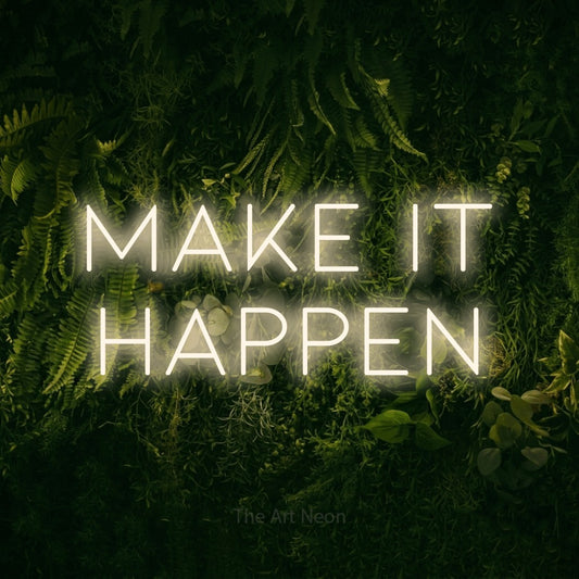 Warm white LED neon sign reading "Make It Happen" against a moss-covered green wall
