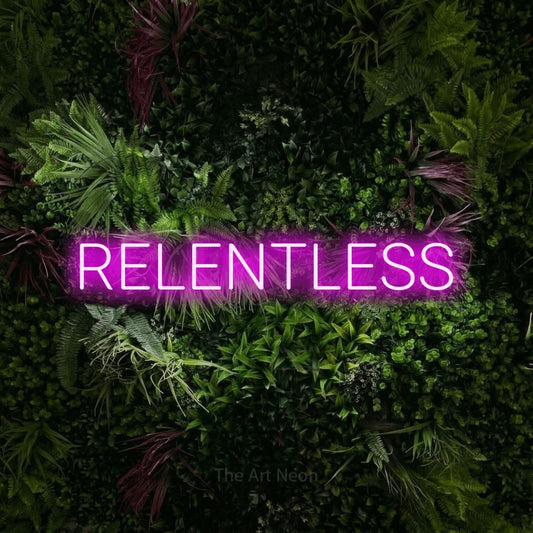 Pink LED neon sign reading "Relentless" against a lush garden wall with pink flowers