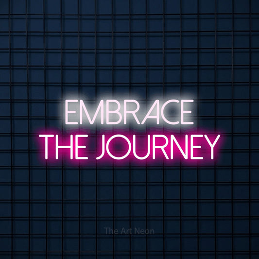 Hot pink and cool white LED neon sign reading "Embrace the Journey" against a dark blue tiled wall