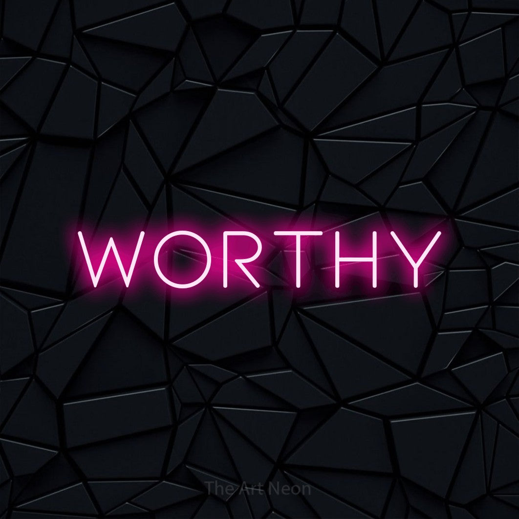 Hot pink LED neon sign reading "Worthy" against a black faceted wall