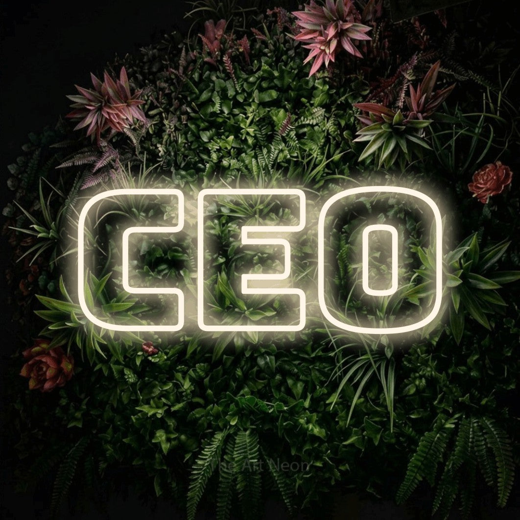 Warm white outline-style LED neon sign reading "CEO" against a flowering garden wall