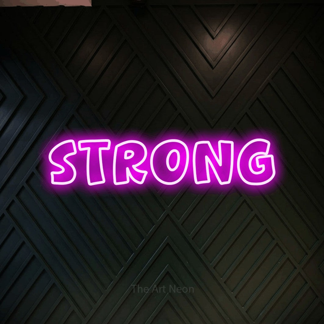 Pink outline-style LED neon sign reading "Strong" against a dark geometric wood wall
