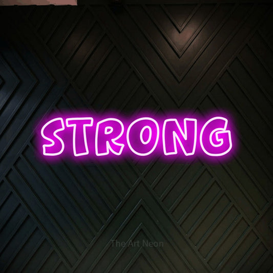 Enseigne néon à DEL à lumière rose, de style contour, affichant « Strong » sur un mur géométrique en bois foncé